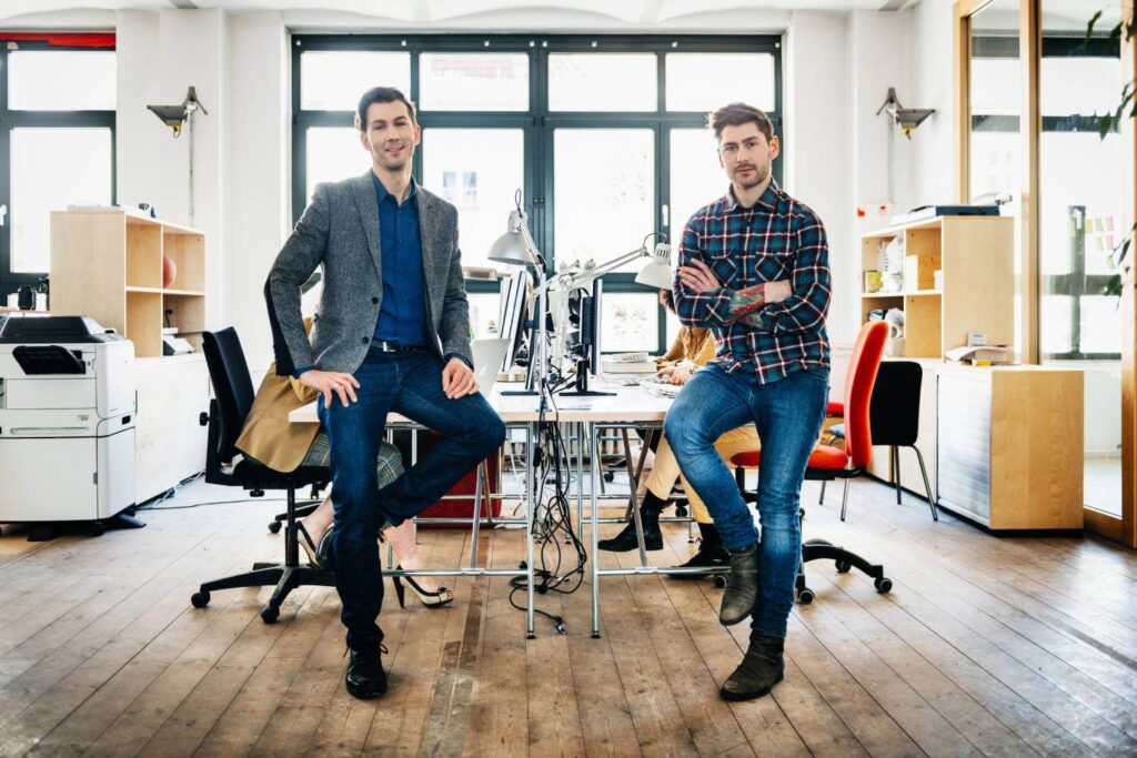 Two male founders in their office looking directly at the camera